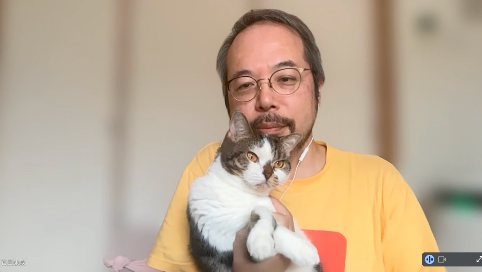 インタビュー中の石田さん。自宅のリビングで、愛猫のおはぎちゃんを抱いている